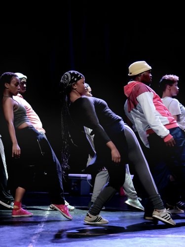 Danseurs se penchant vers l’arrière, la jambe tendue vers l’avant dans Via Injabulo