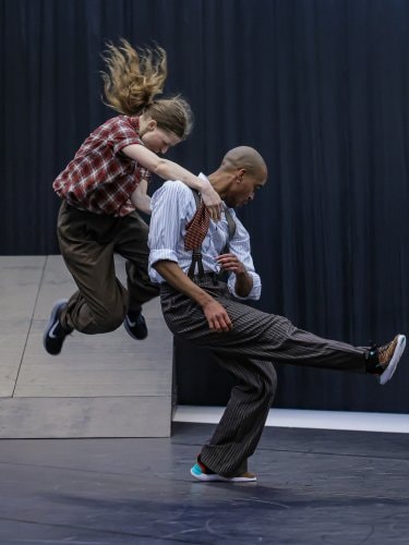Deux danseurs en plein saut.