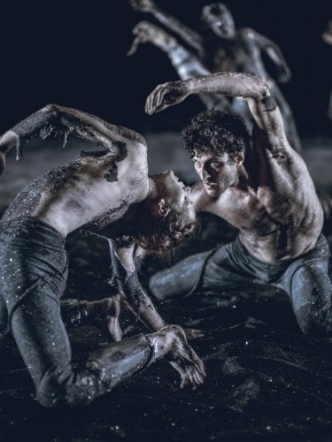Dancers on the ground on sand