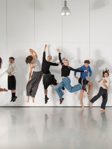 Ten dancers jumping on a white background.