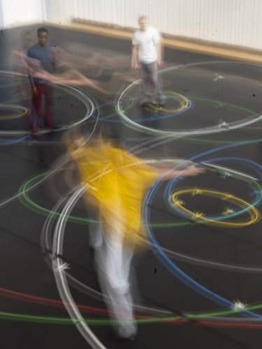 People moving, creating colorful light trails