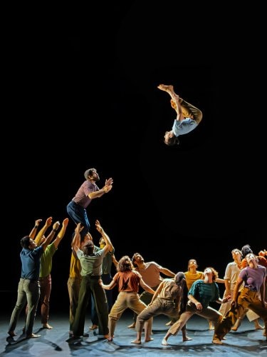 Group lift with a dancer performing a salto