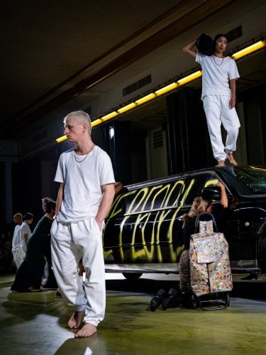 dancers on stage in front of a car
