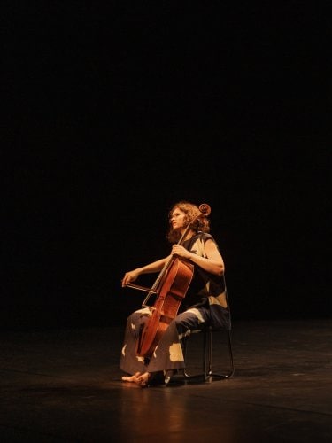 Cellist and dancer in black manipulating a white veil