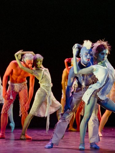 group of dancers performing with colorful body paint