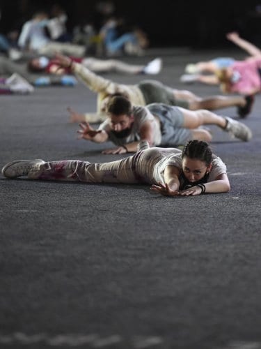 Performers lying and crawling on a stage