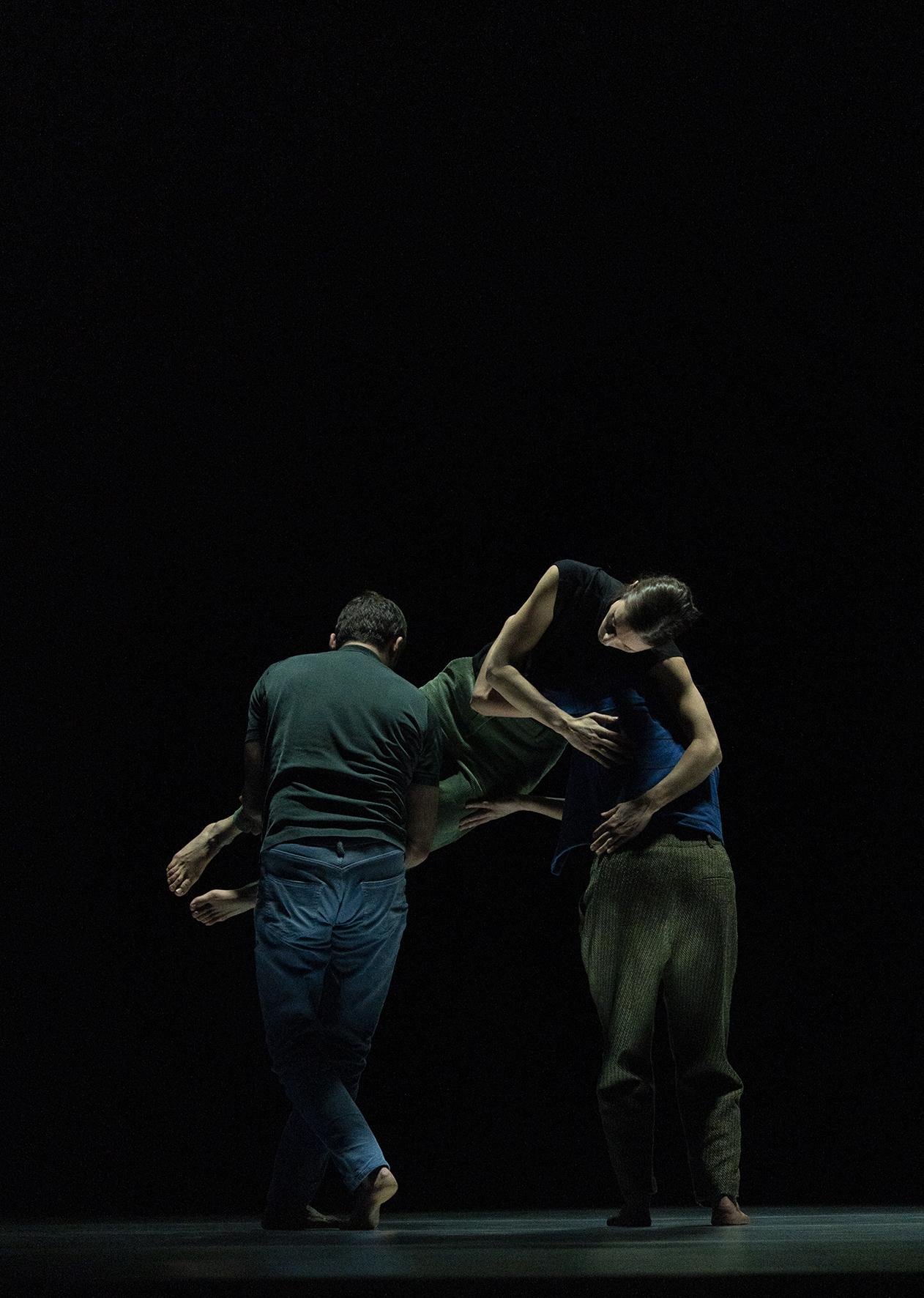 Deux danseurs de dos portant un troisième danseur de face