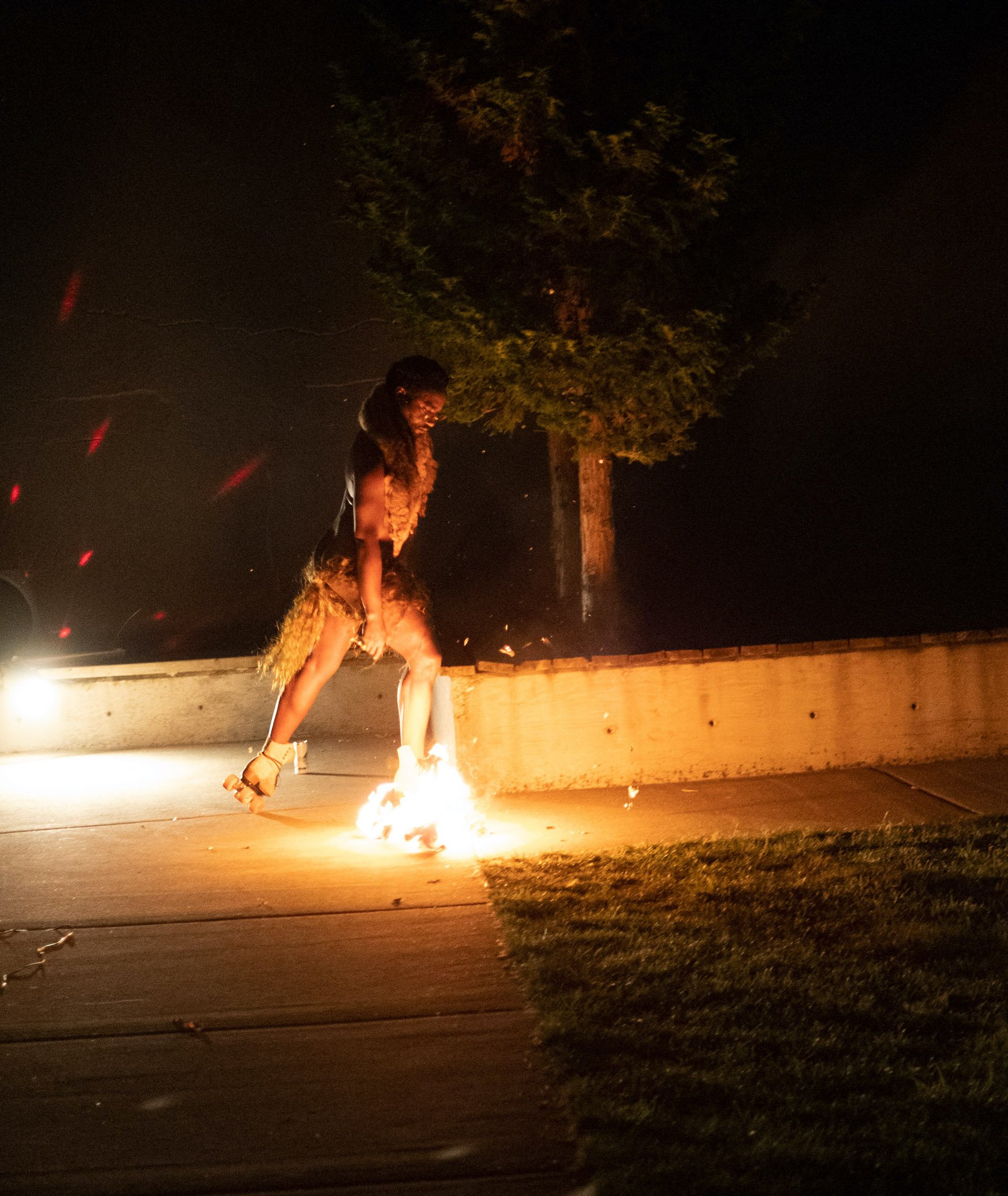 a dancer rollerskating during nighttime with one boot on fire