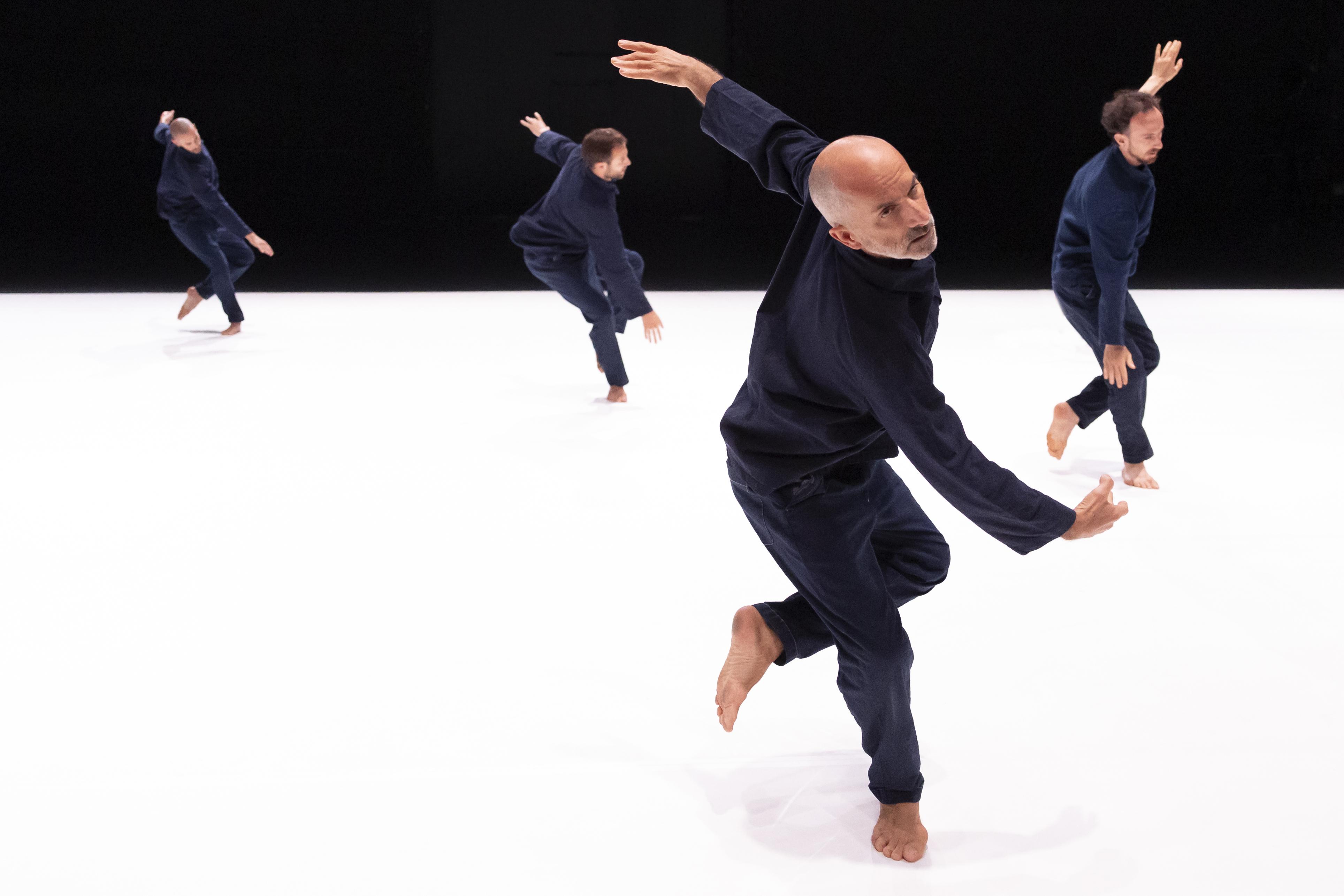 danseurs vêtus de bleus de travail, renversés vers l’avant avec un bras en arrière