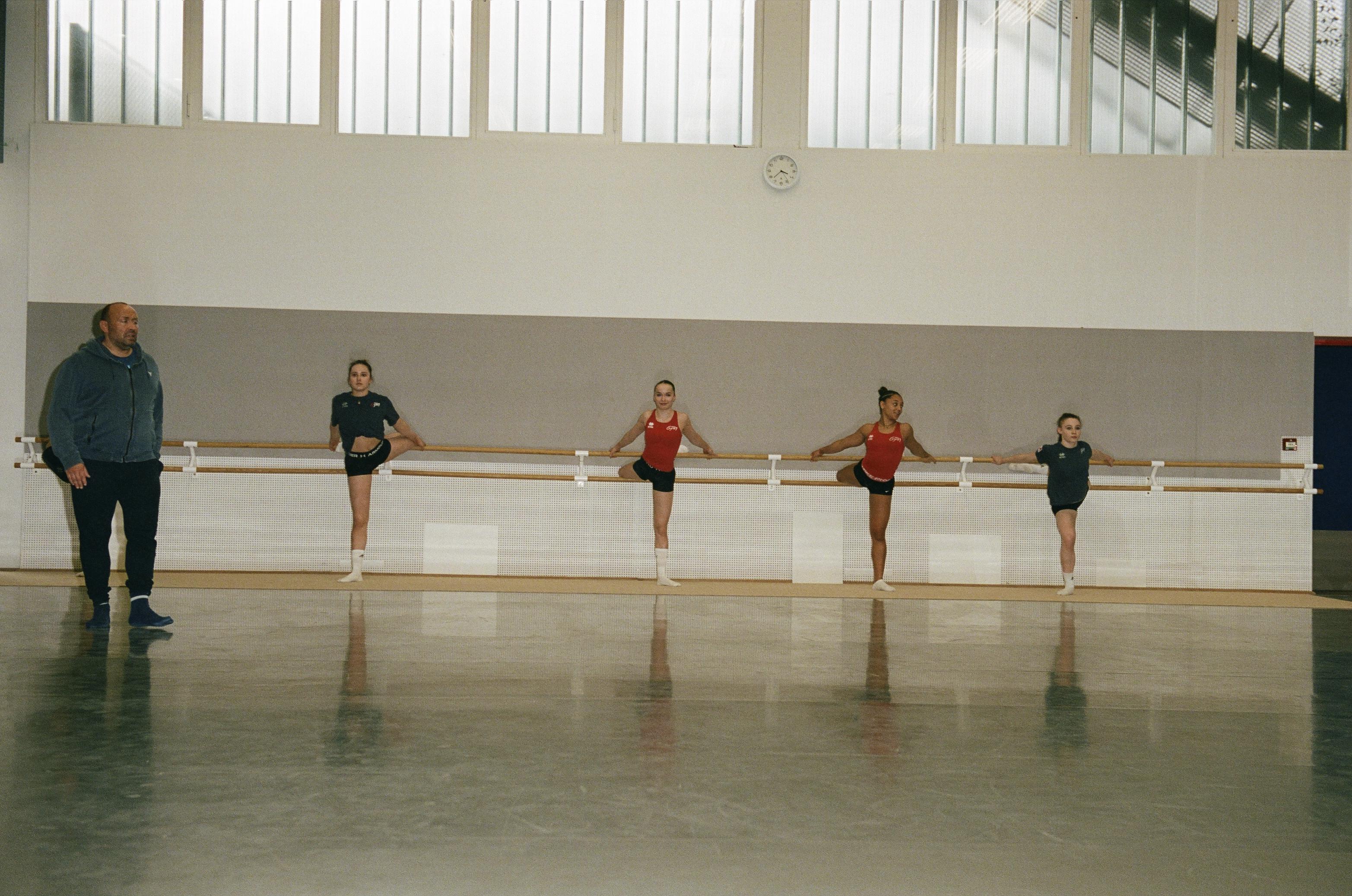 Gymnasts with their foot on the bar