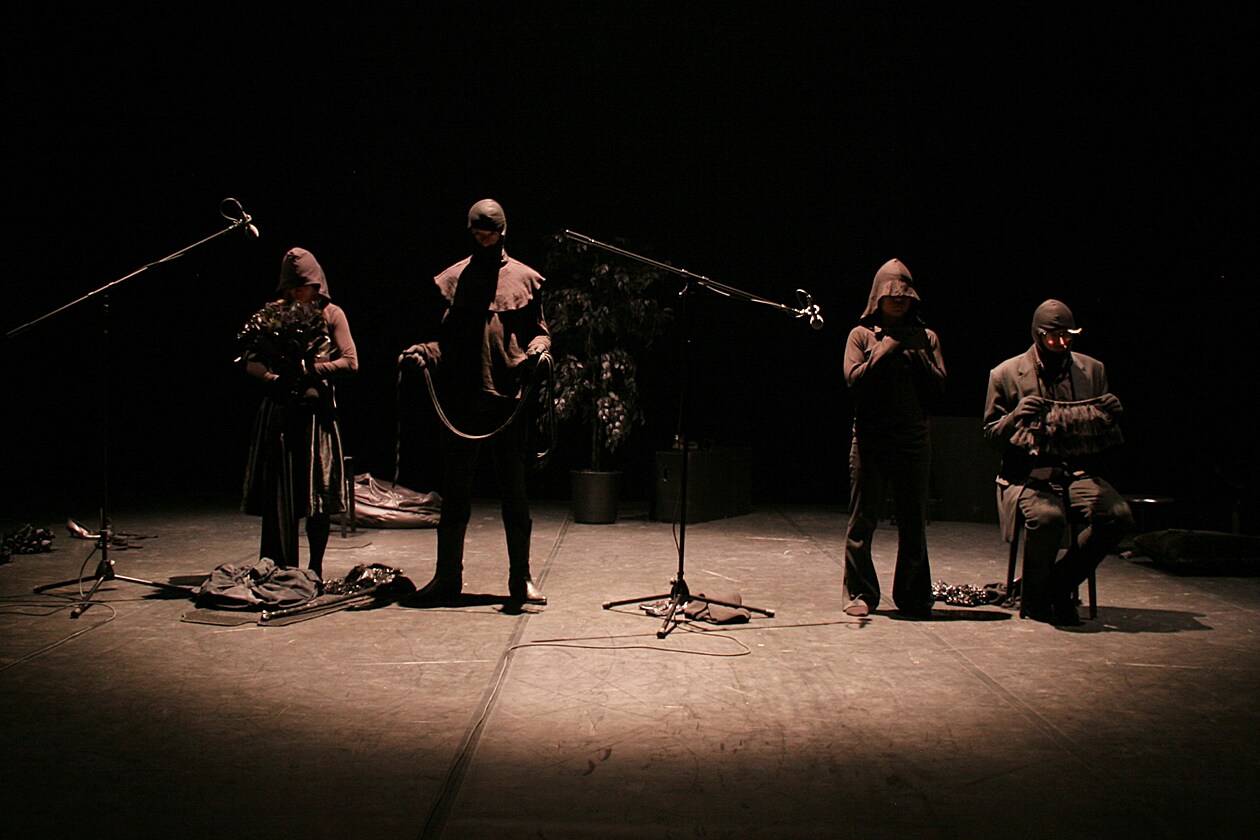 Groupe de quatre musiciens sur scène dans la pénombre