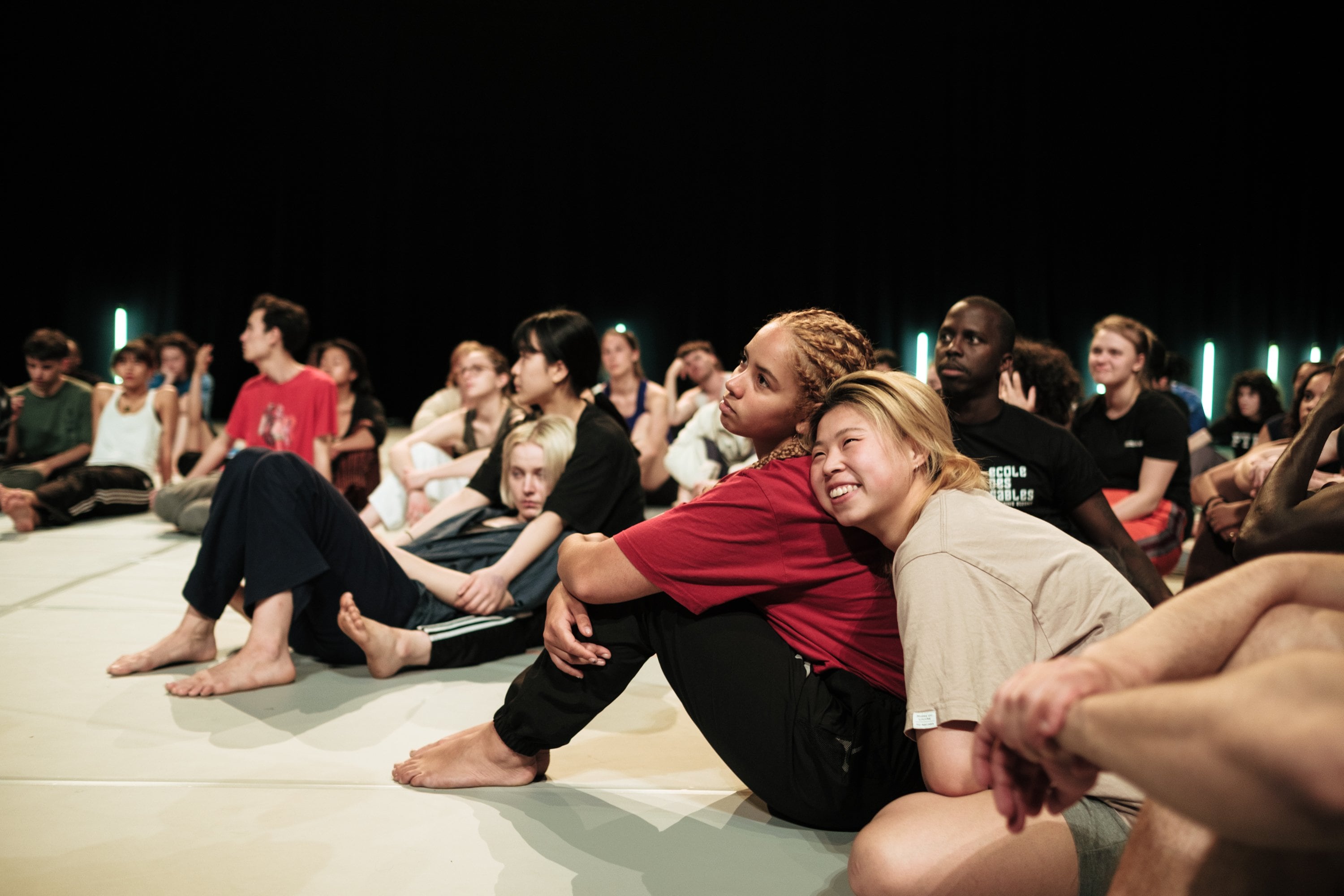 A group of smiling dancers sitting close together