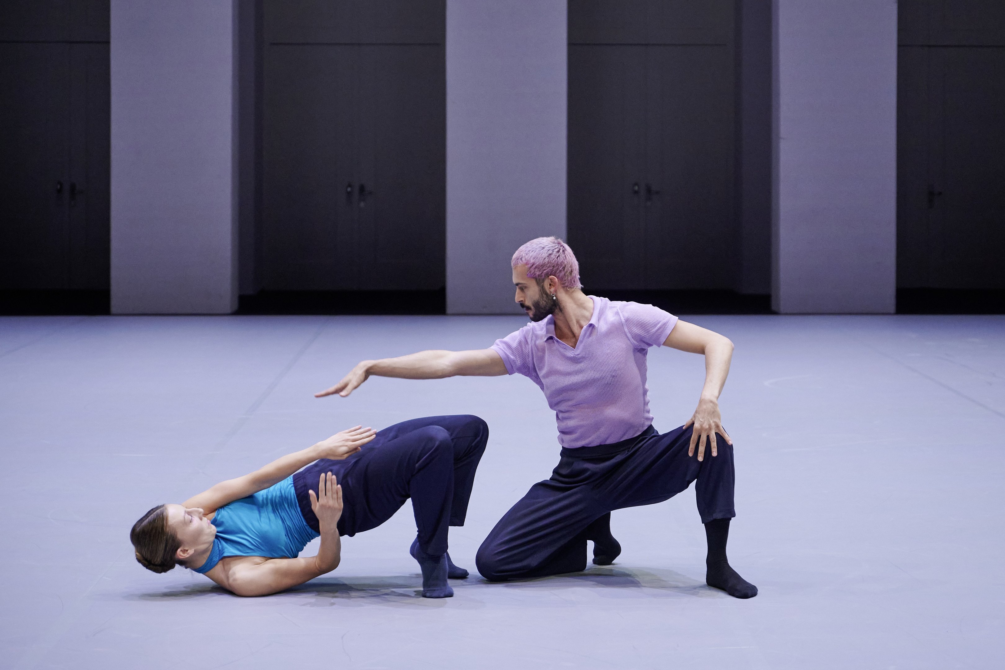 une danseuse au sol et un danseurs à genoux 