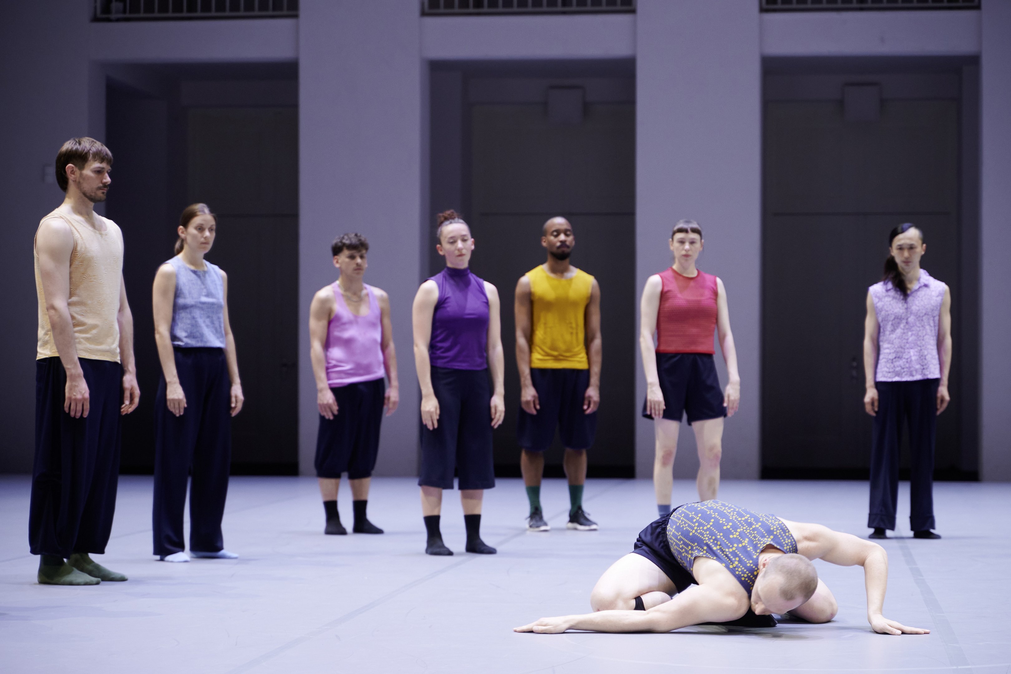 un groupe de danseurs regardent un autre danseurs sur le sol 