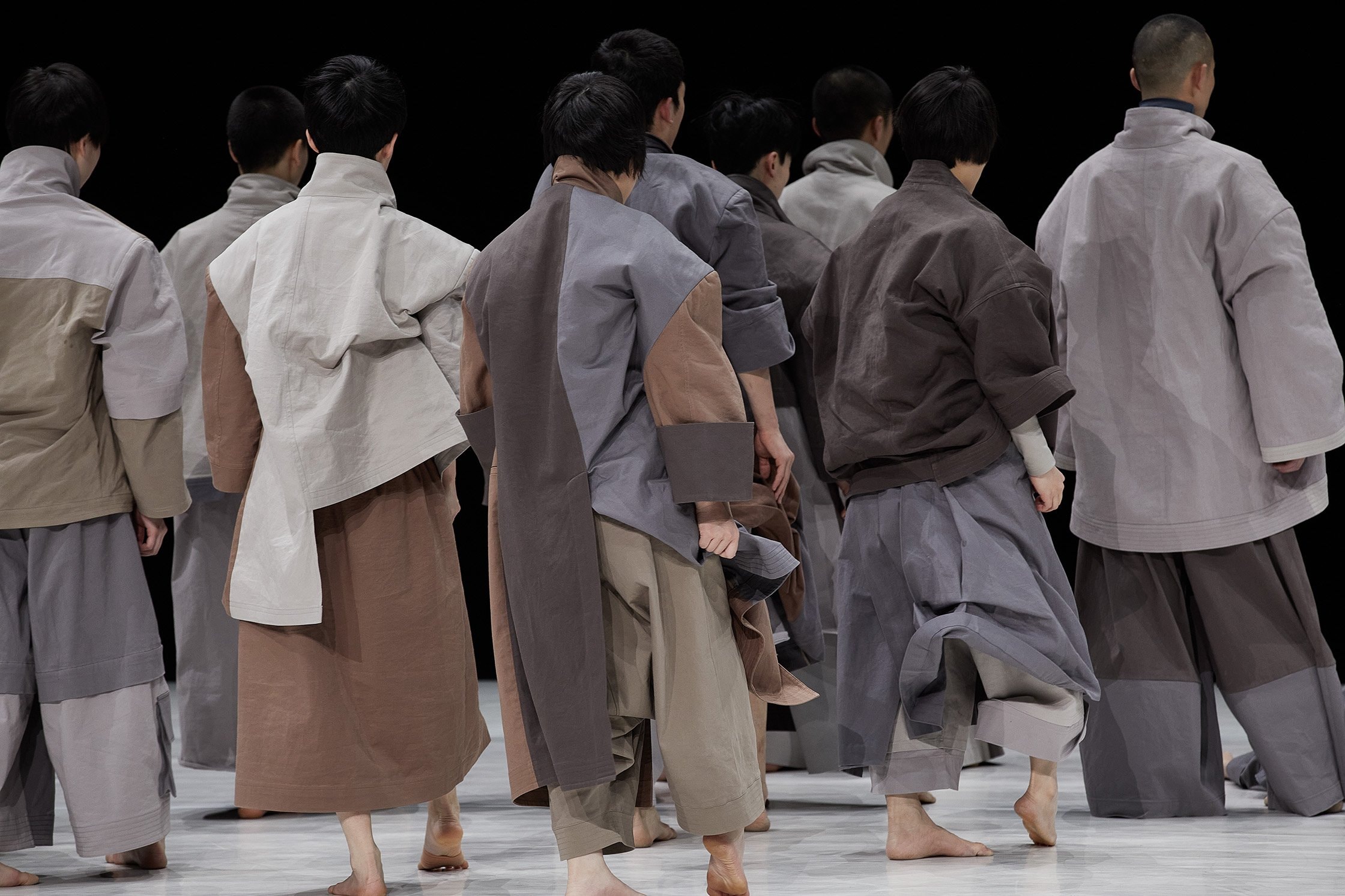 danseurs debout de dos, la tête baissé