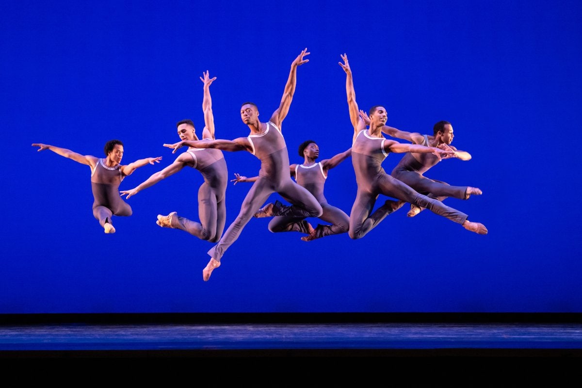groupe de 6 danseurs performant devant un fond bleu 