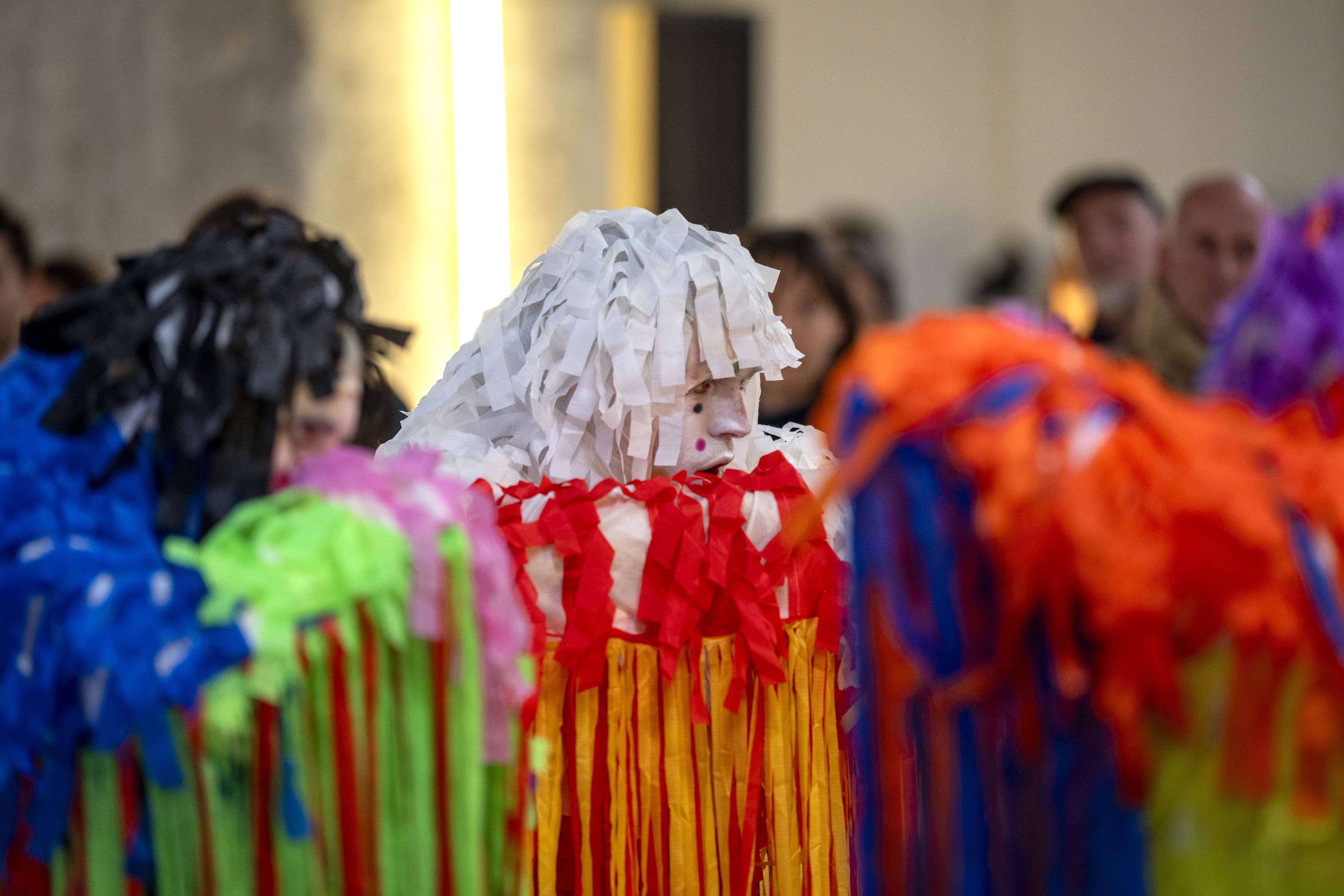 Dancers in paper costumes of different colors