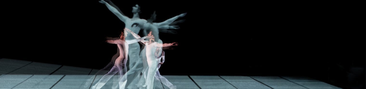 Danseurs qui sautent ensemble dans des costumes blanc sur fond noir