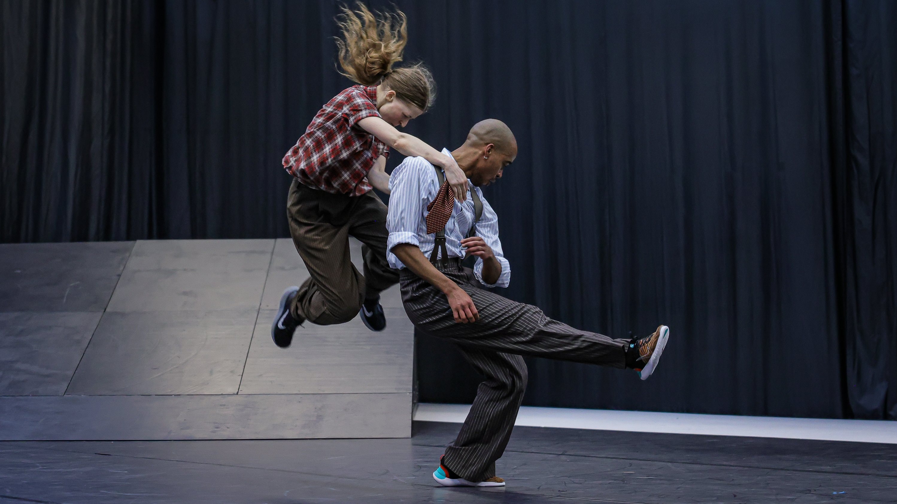 Deux danseurs en plein saut.