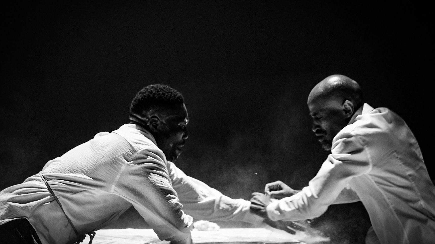Two men in whit shirts at a table, black and white photo.
