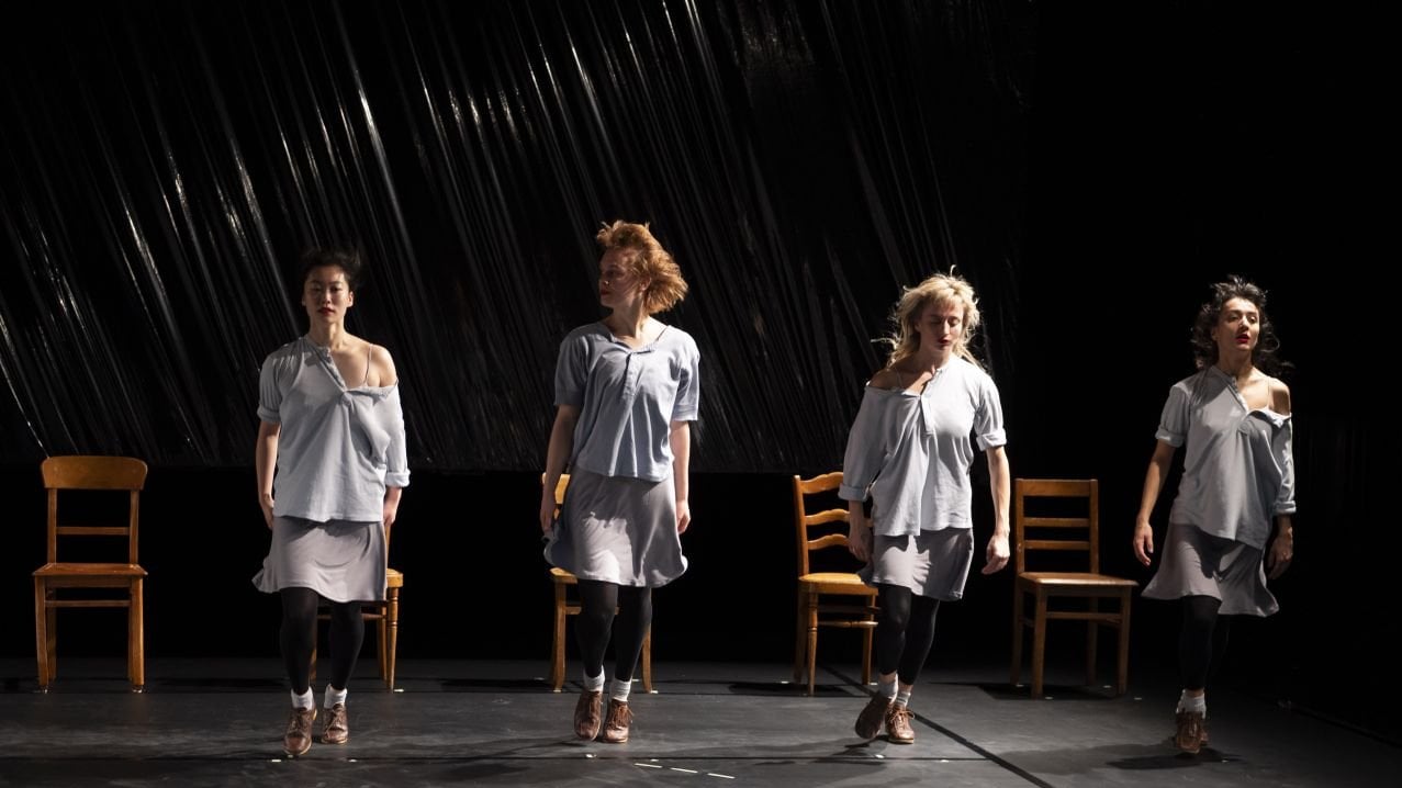 4 danseuses debout devant des chaises