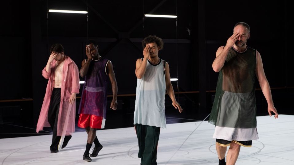 4 danseurs sur scène en ligne sur un sol blanc