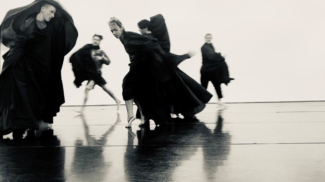  several dancers performing in flowing black costumes