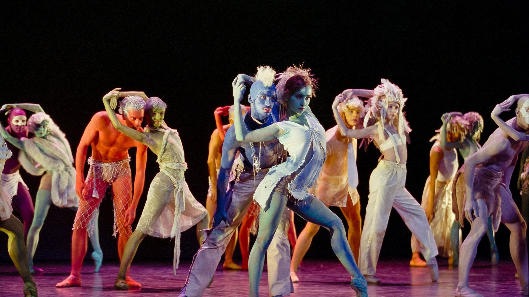 group of dancers performing with colorful body paint
