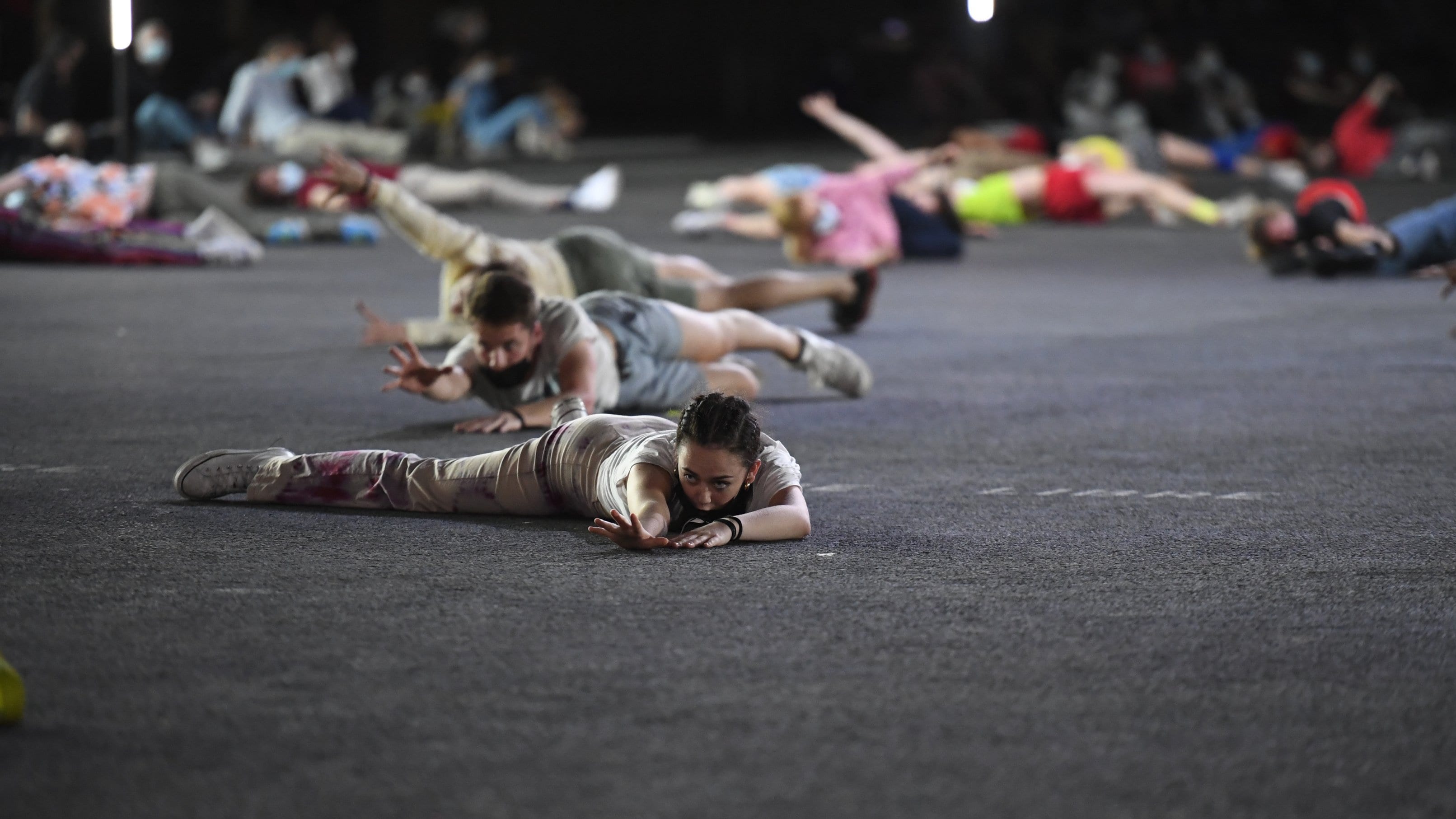 Performers lying and crawling on a stage