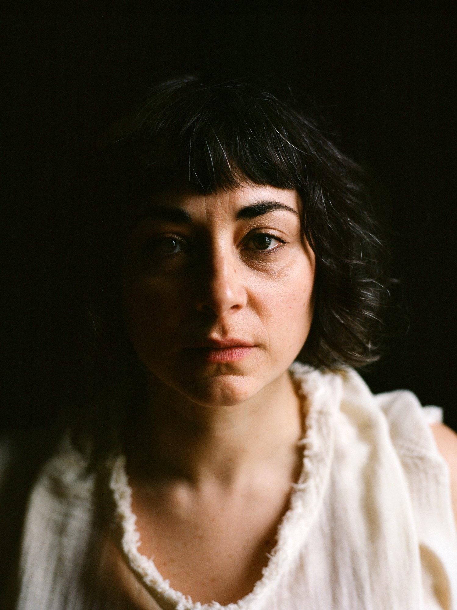 portrait ombré de Beth Gill dans un espace sombre